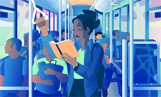 Woman reading a book standing on a crowded bus holding a strap