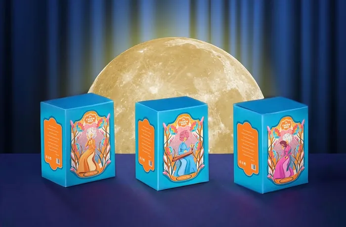 Three blue lanterns with angel art placed on a surface with full moon backdrop.