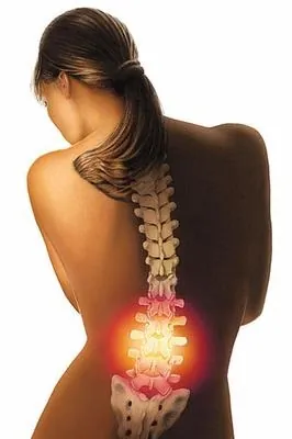 Woman's back showing illuminated lower spine highlighting pain area by Eberhard Reimann