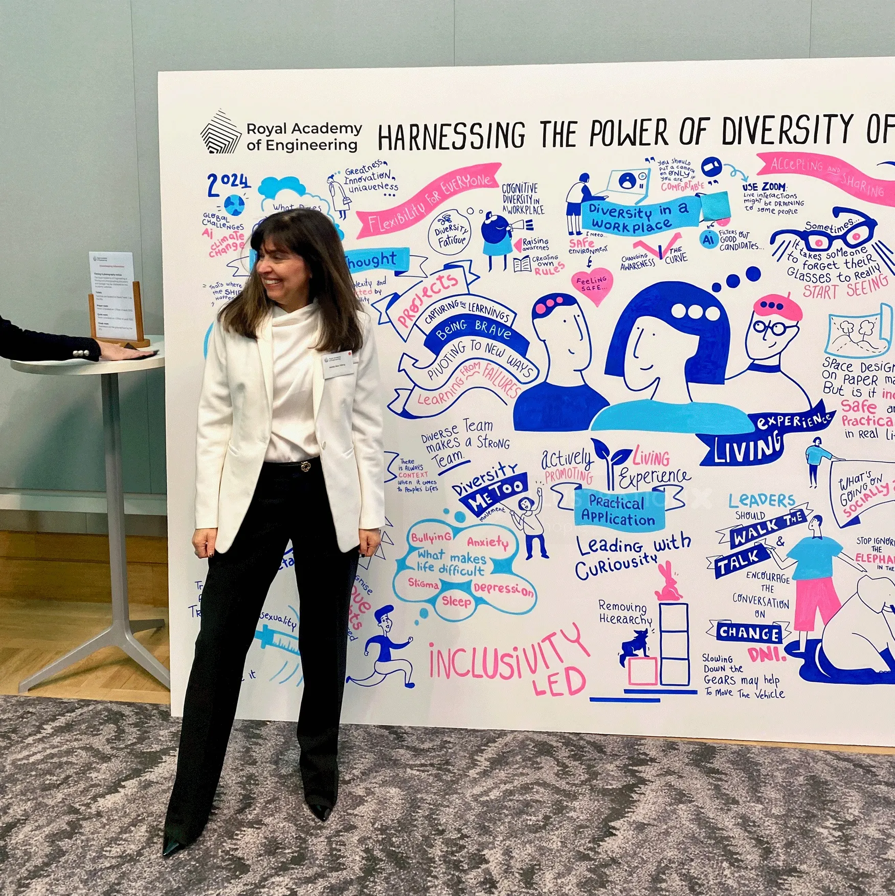 Woman in white blazer beside colorful diversity and inclusivity illustration