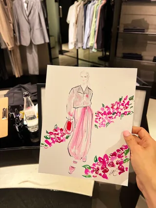 Hand holding fashion sketch with pink floral accents by Elise Lee