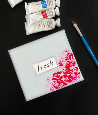 Paint tubes and brush with painted red roses on Fresh package by Elise Lee