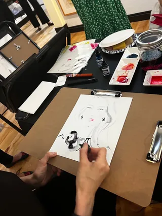 Artist Elise Lee sketching a live portrait with painting supplies