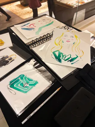Fashion illustration sketches displayed on table by Elise Lee Live Event Drawing