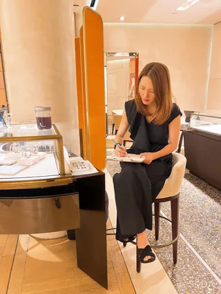 Woman sketching while seated at Bulgari event by Elise Lee