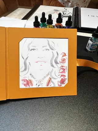 Artistic portrait sketch with colorful ink bottles on table
