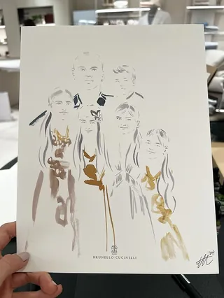 Hand holding fashion illustration of five people in elegant outfits