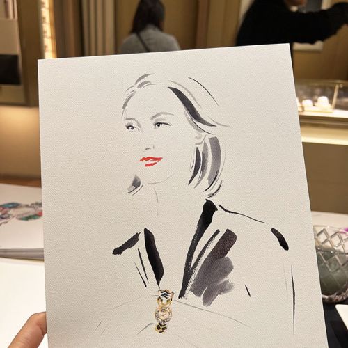 Hand holding fashion illustration with necklace at Cartier event