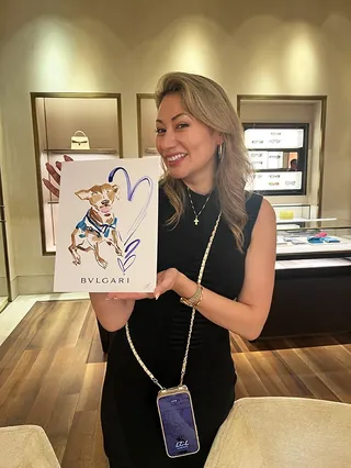 Smiling woman holding Bvlgari shopping bag with cartoon design