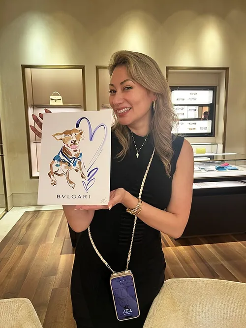 Smiling woman holding Bvlgari shopping bag with cartoon design