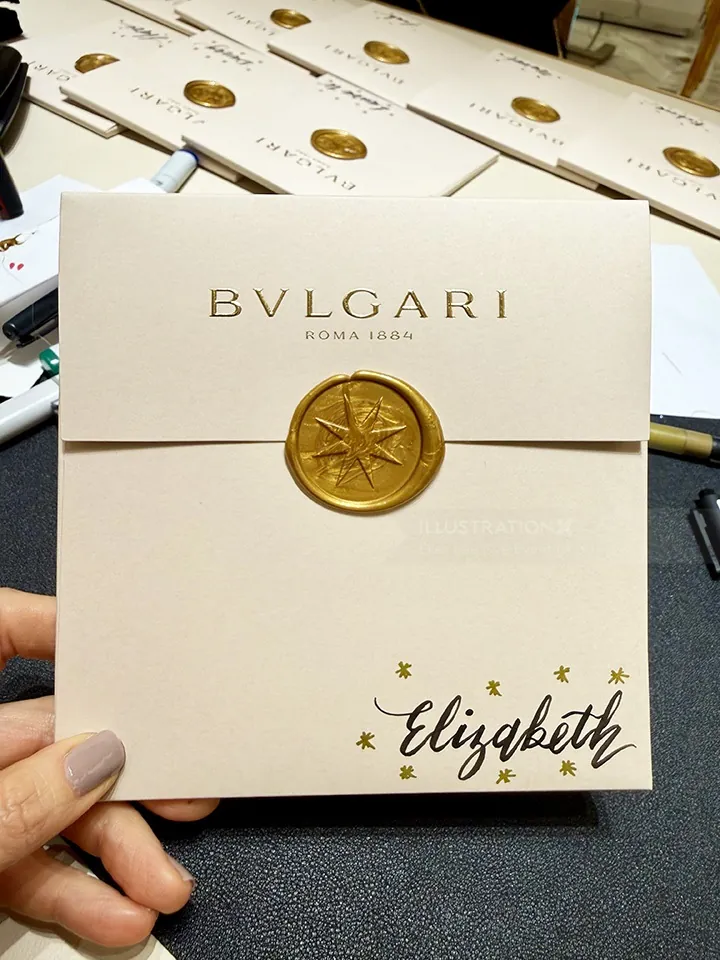 Hand holding BVLGARI envelope with gold wax seal and handwritten Elizabeth by Elise Lee Live Event D