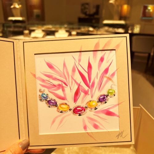 Hand holding BVLGARI jewelry illustration with colorful gems by Elise Lee