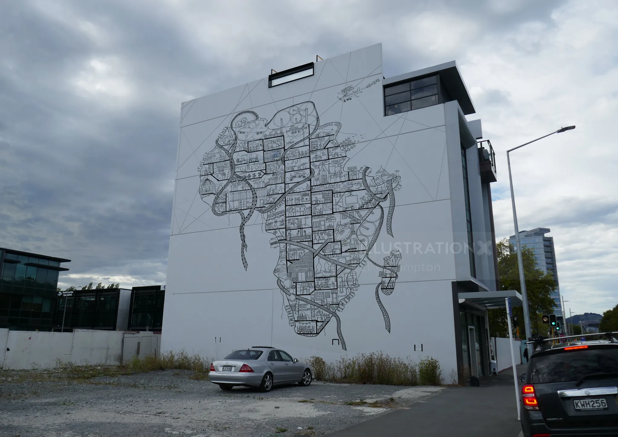 Large mural map on building wall by Ellie Compton with cars in foreground