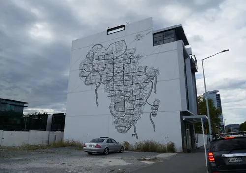 Large mural map on building wall by Ellie Compton with cars in foreground