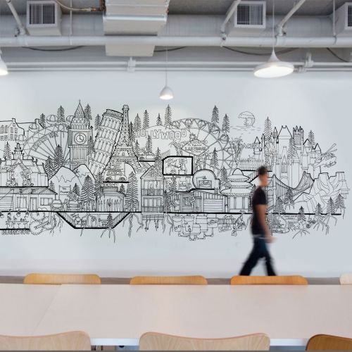 Cityscape mural in black and white on wall with person walking by, artist Ellie Compton