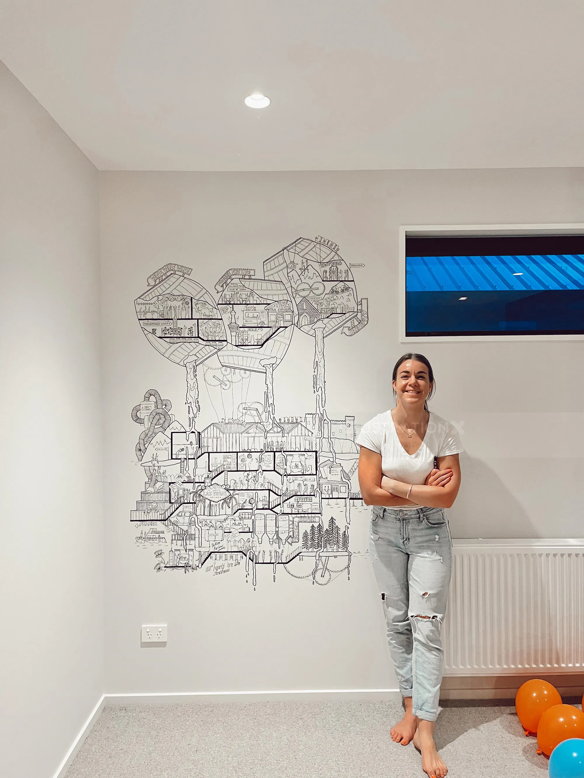 Woman posing beside detailed black and white mural on white wall