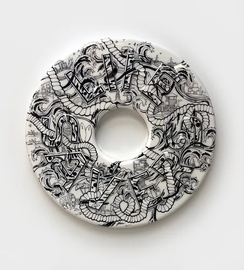 La sculpture illustrée d'une bouée de sauvetage de Ellie Compton est recouverte de dessins complexes en noir et blanc.