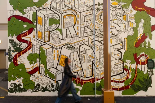 Fresque murale Ellie Compton représentant l'inscription « Press Lane », des artistes, des plantes et la faune locale
