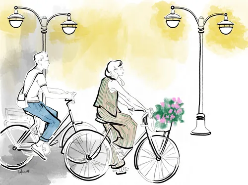 Two people biking under street lamps at night, one with flowers in basket.