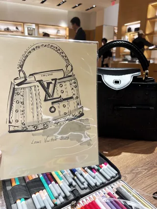 Sketch of a Louis Vuitton handbag by Elly Azizian with real bag in background