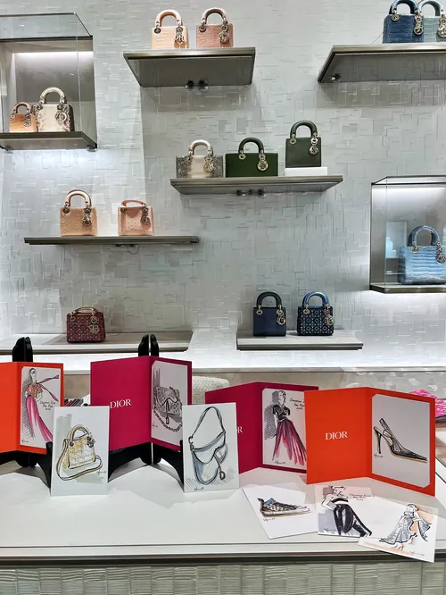 Luxury handbags on shelves with fashion sketches on table by Elly Azizian
