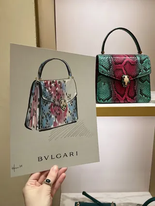 Hand holding Bvlgari handbag illustration with real handbag behind
