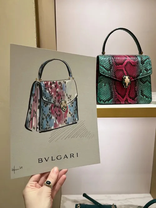 Hand holding Bvlgari handbag illustration with real handbag behind