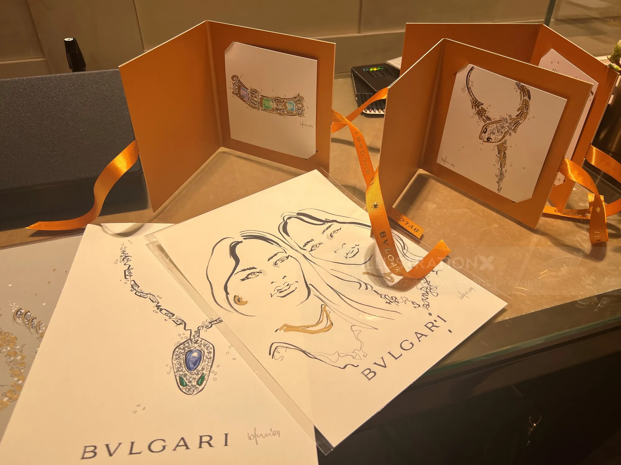 Bocetos y retratos de joyas de BVLGARI en papel con carpetas naranjas