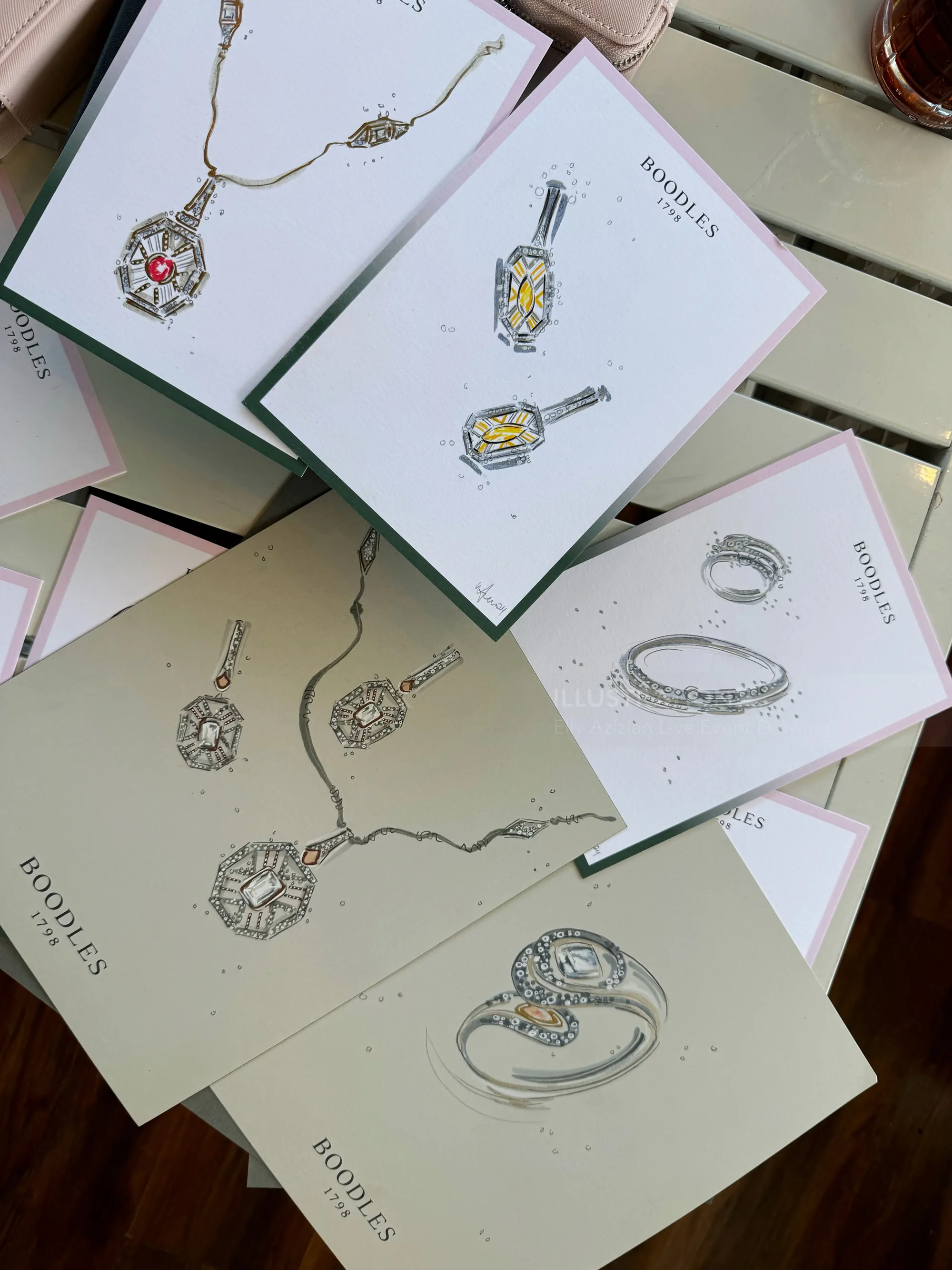 Folletos abiertos con bocetos de anillos, collares y colgantes.