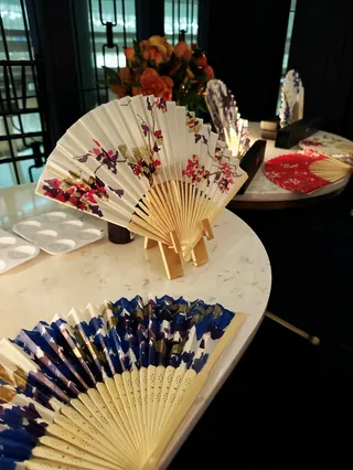 Various decorative hand fans with floral designs on a table