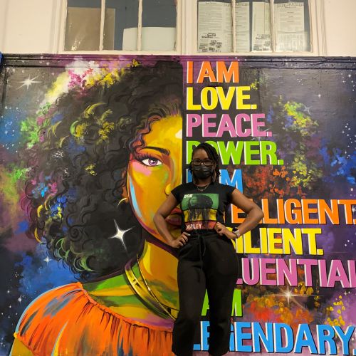 Mural of woman with curly hair and empowering words by Esther Stimphat