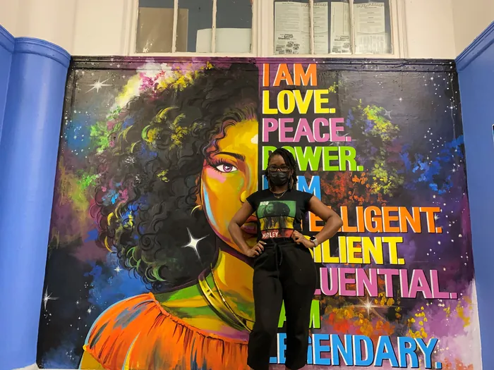 Mural of woman with curly hair and empowering words by Esther Stimphat