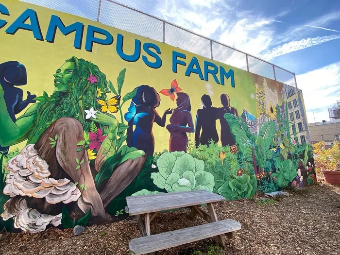 Mural showing silhouetted people and vibrant plants at Campus Farm by Esther Stimphat