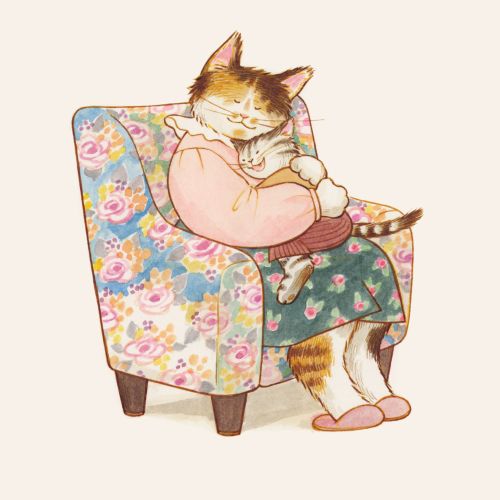 Mother cat hugging kitten on floral armchair