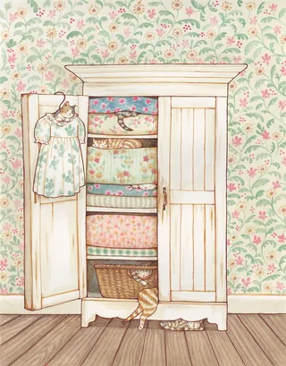 Open wooden wardrobe with folded floral fabrics and hanging dress