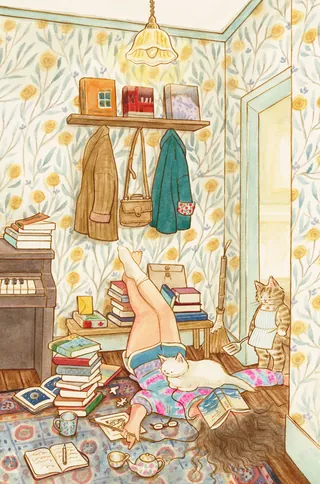 Person lying on floor reading book with books and cat nearby