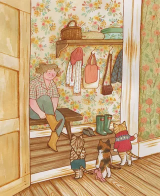 Woman putting on boots while three dressed cats watch on wooden floor.