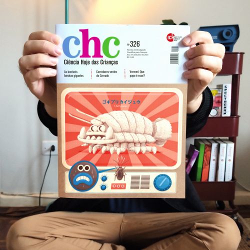 Hands holding Ciencia Hoje das Criancas magazine with cartoon woodlouse cover