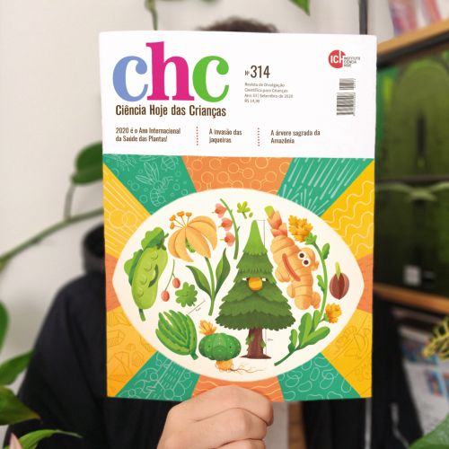 Person holding Ciencia Hoje das Crianças magazine with plants and animals