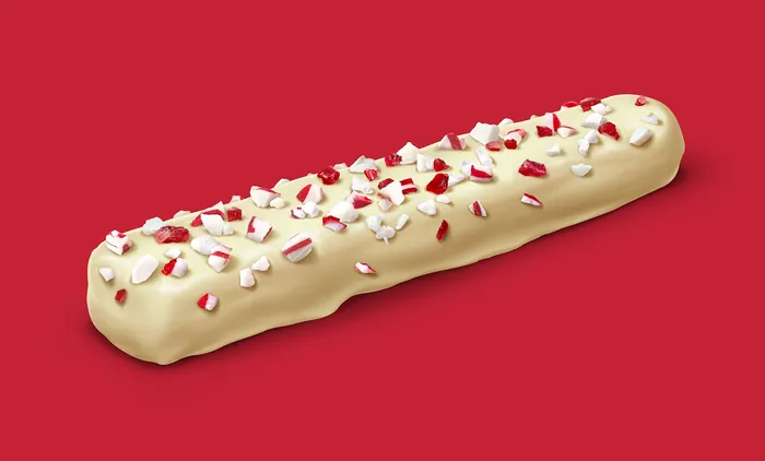 White chocolate peppermint bark bar with crushed candy on red background