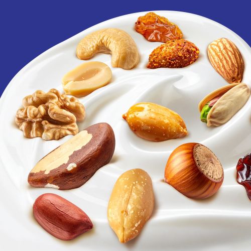 Various nuts arranged on creamy swirled yogurt by Food For Thought