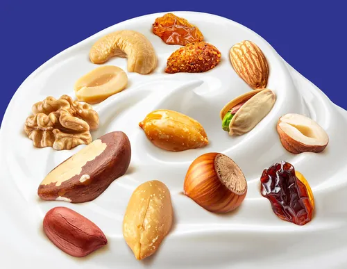 Various nuts arranged on creamy swirled yogurt by Food For Thought