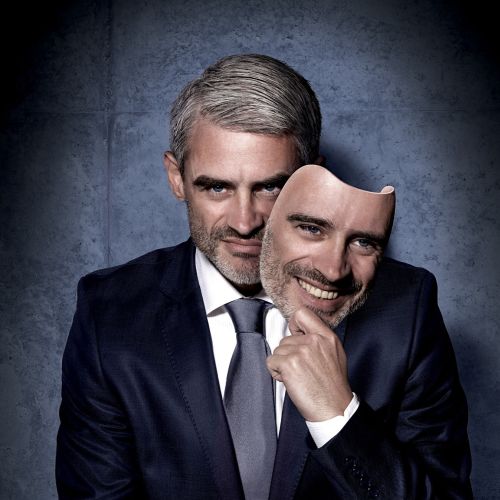 Man in suit holding a smiling face mask, artwork by Frank Neidhardt