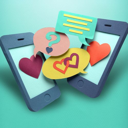 Paper smartphones with chat bubbles and hearts on teal background