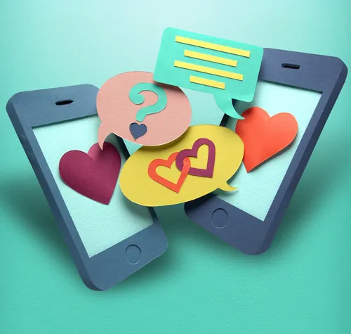 Smartphones aus Papier mit Sprechblasen und Herzen auf türkisfarbenem Hintergrund