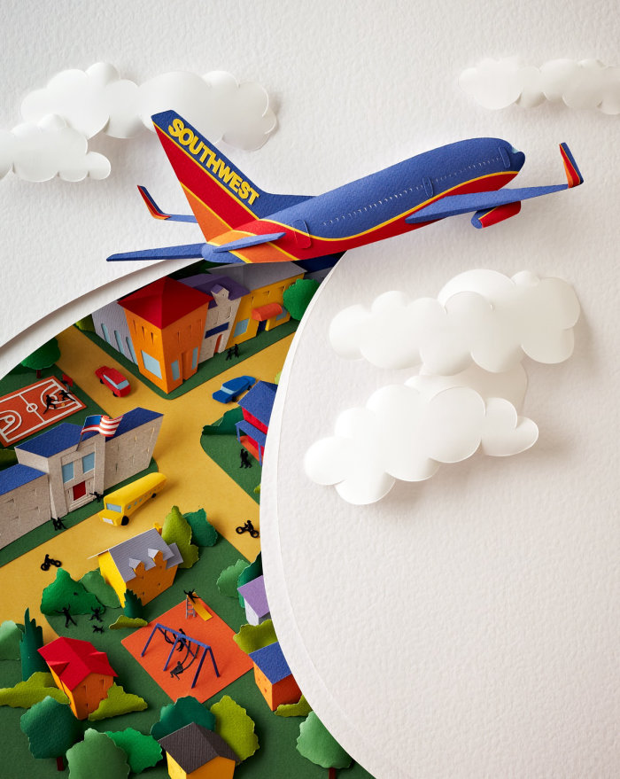 Imagen de la escultura de papel de un avión de SouthWest Airlines cortando el cielo y las nubes