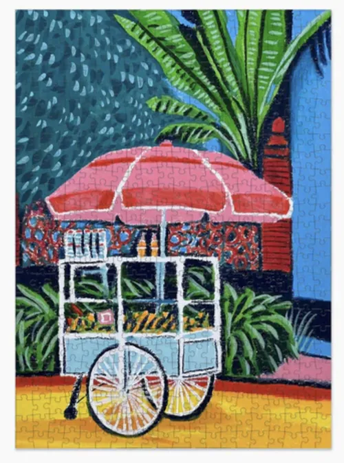 Colorful tropical food cart by Georgie Stewart with umbrella, bicycle wheel, and lush plants.