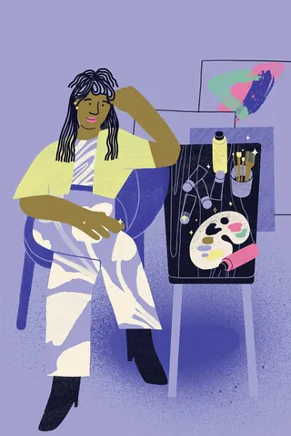 Woman sitting beside paint palette and brushes on table