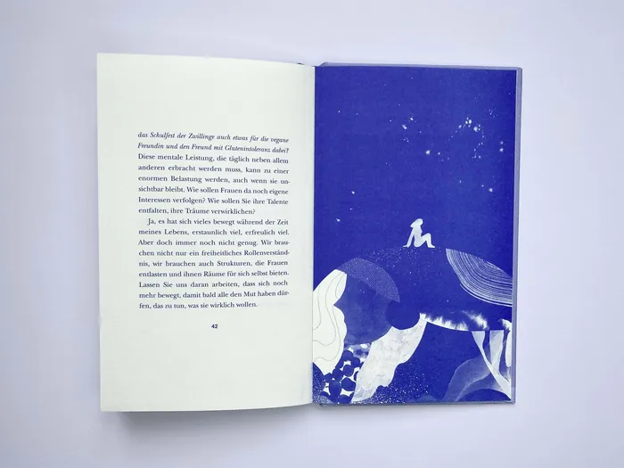 Open book with German text on left and blue artwork on right