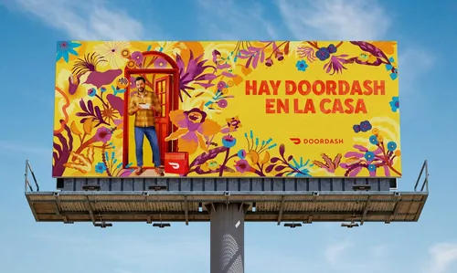 Gina Rosas Moncada billboard for DoorDash shows colorful Spanish lettering and tropical food deliver